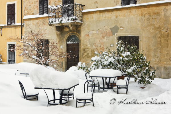 Schneebedeckte Tische und Stühle in Pienza, Toskana